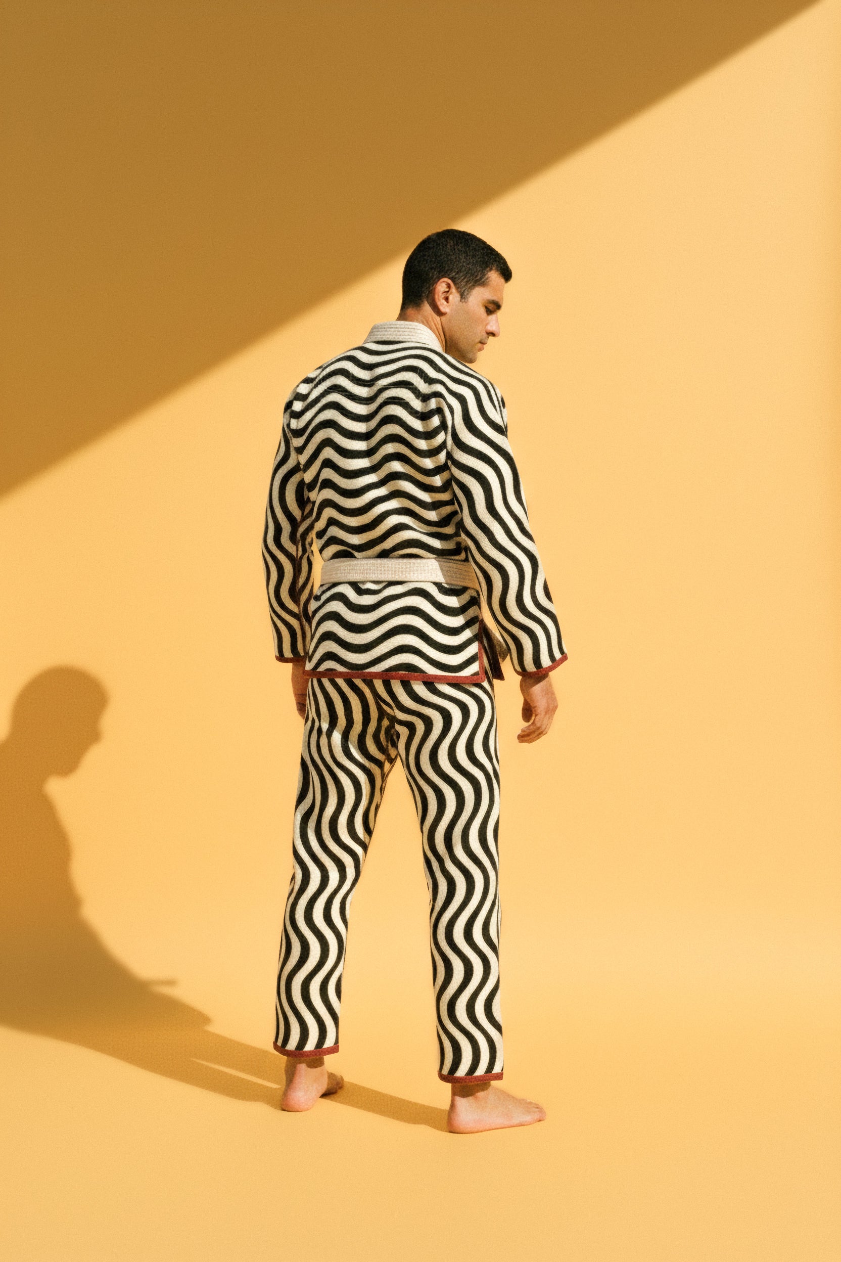 bad optics jiujitsu gi with swirling black and white optical illusion pattern and red accent trims. 
